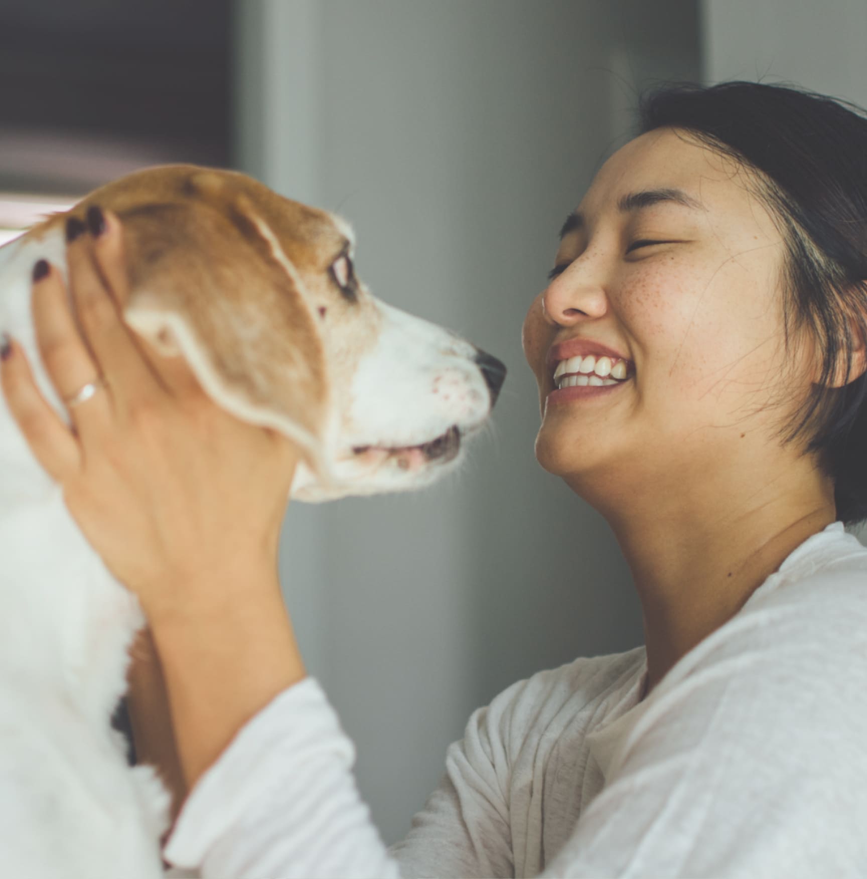 woman cuddling a small dog
